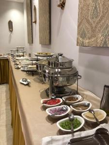 a buffet line with bowls and plates of food at Holiday Season in Tabuk