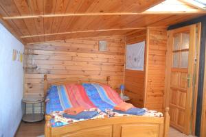 a bedroom with a bed in a wooden cabin at Apartament nad Jeziorem Necko in Augustów