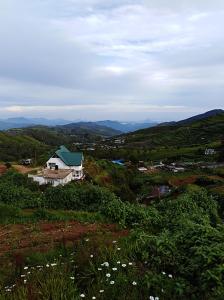 a house on a hill with mountains in the background at White house in Nuwara Eliya