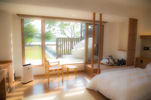 a bedroom with a bed and a desk and a window at Kangetsuen in Otofuke