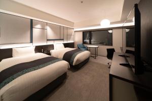 Säng eller sängar i ett rum på Hotel Vischio Osaka-JR Hotel Group