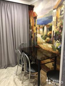 ウラジカフカスにあるОднокомнатная квартираのダイニングルーム(テーブル、椅子、絵画付)