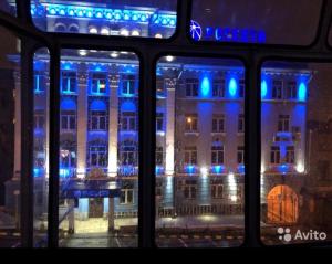 ウラジカフカスにあるОднокомнатная квартираの青い照明の建物のバス窓からの眺め