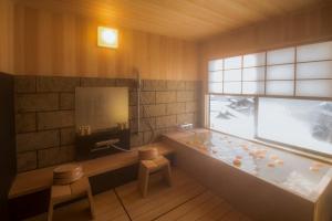 a bathroom with a bath tub and a window at Yamanoo in Kanazawa