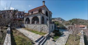 an old stone building with a church on a hill at Stone Mansion Anavryti, ΑΜΑ 20569 in Mystras