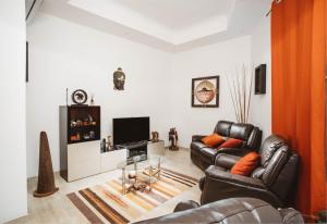 uma sala de estar com duas cadeiras de couro e uma televisão em Fauzia B&B em Hamrun