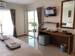 a bedroom with a bed and a tv and a mirror at Crystal Lamai Hotel in Lamai