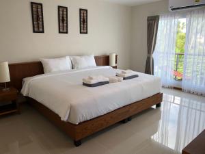 a bedroom with a large bed with two towels on it at Crystal Lamai Hotel in Lamai