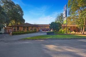 a building with a sign on the side of a road at Pleasant Way River Lodge in Nowra