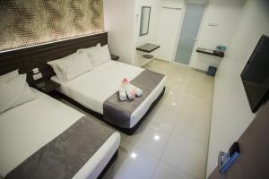 a bedroom with two beds and a doll sitting on the bed at IM 96 Villa in Kuantan