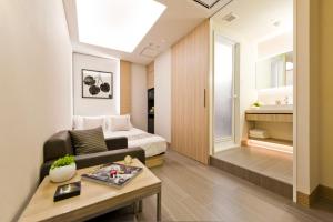 Habitación con cama, sofá y mesa. en HOTEL ROY(Adult Only), en Yokohama