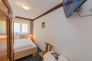 a small bedroom with a bed and a table at BIO-Bauernhof Hatzbauer in Maria Alm am Steinernen Meer