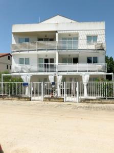 un edificio bianco con una recinzione di fronte di Venus near beach CUVI apartment a Rovigno (Rovinj)
