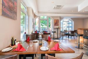a dining room with a table with red napkins at Best Western Hotel Airport Düsseldorf - Ratingen in Ratingen
