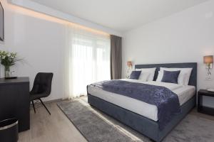 a bedroom with a bed and a desk and a chair at Pansion Leggero in Krk