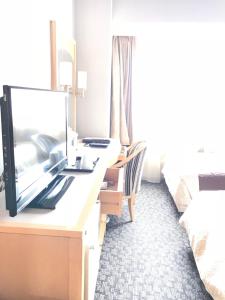 a hotel room with a desk with a television on it at Numazu River Side Hotel in Numazu