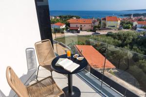 a balcony with a table and chairs and a view at Pansion Leggero in Krk
