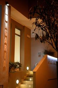 a hotel lobby with stairs and a neon sign at Residence Hotel Hungaria in Grado