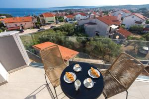 a table with plates of food on top of a balcony at Pansion Leggero in Krk