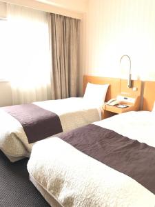 Una cama o camas en una habitación de Numazu River Side Hotel