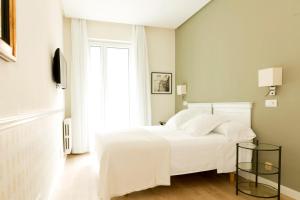 ein Schlafzimmer mit einem weißen Bett und einem Fenster in der Unterkunft Hotel Sauce in Saragossa