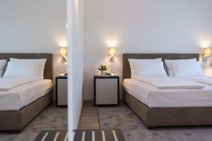 a bedroom with two beds and two night stands at Pansion Leggero in Krk