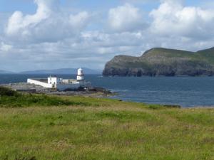 un faro sulla riva di un corpo d'acqua di Harbour View Cottage a Valentia Island