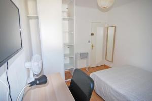 モンペリエにあるChambre Montpellier Campanules (home sharing)のベッド、デスク、ファンが備わる客室です。