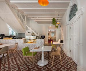 a lobby with tables and chairs and a staircase at Macalister Mansion in George Town