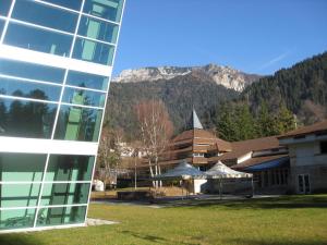 a building next to a building with a mountain in the background at Sot I Volz - Affittacamere in Arta Terme