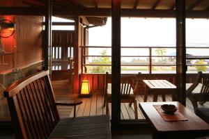 un restaurante con mesa, sillas y ventanas en Taiseikan en Atami