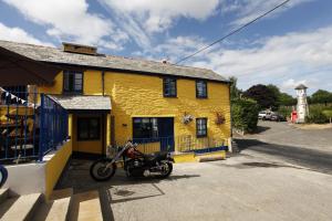 a motorcycle parked in front of a yellow building at Rod and Line in Landrake