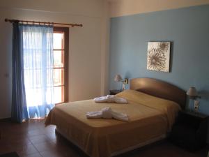 a bedroom with a bed with two towels on it at Ikaria Utopia - Cusco Studios in Évdhilos