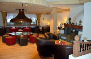 a restaurant with chairs and tables and a large bell at Parkhotel Kirchberg in Kirchberg in Tirol