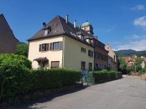 una casa blanca con techo negro en una calle en KAYSERSBERG city center - COTE VIGNOBLE -, en Kaysersberg