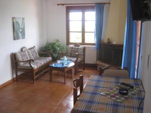 een woonkamer met een bank en een tafel bij Ikaria Utopia - Cusco Studios in Evdilos