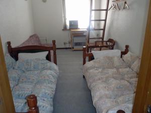 1 dormitorio con 2 camas y ventana en Mont Cervin, en Myoko