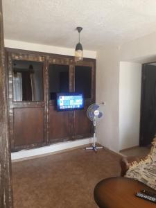 a living room with a flat screen tv and a fan at Lucy B&B in Goris