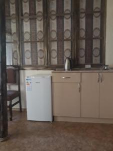 a kitchen with a white refrigerator and a chair at Lucy B&B in Goris