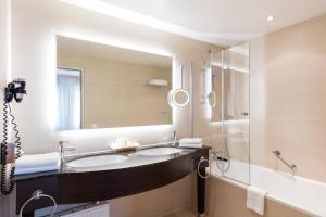 a bathroom with a sink and a shower and a mirror at Hotel Europäischer Hof Hamburg in Hamburg