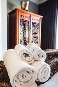una pila de toallas sentadas encima de una cama en 512 The Granger, en Ciudad del Cabo