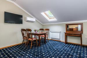 ガリャーチ・クリュチにあるResidence Park Hotelのテーブルと椅子、薄型テレビが備わる客室です。