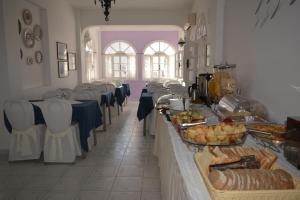uma fila de buffet num restaurante com mesas e cadeiras em Melina Hotel em Fira