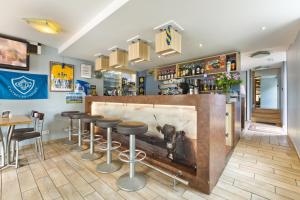 een bar in een restaurant met krukken ervoor bij Logis Hotel De La Poste in Saint-Sauves- dʼAuvergne