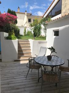 - une terrasse avec une table, des chaises et des fleurs dans l'établissement 26 avenue des Tilleuls, à Royan