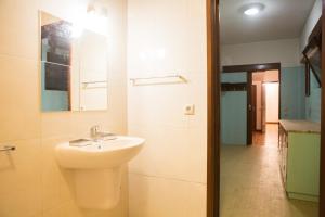 a white bathroom with a sink and a mirror at Hostel Casa das Regadas in Vale de Cambra