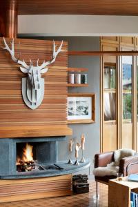 a living room with a fireplace with a deer head on the wall at Hotel Tremoggia in Chiesa in Valmalenco