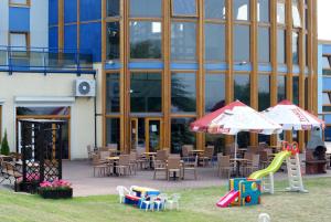 a building with tables and chairs and an umbrella at Hotel Panorama in Szczecin