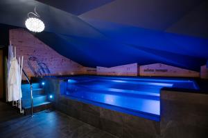 a swimming pool in a room with blue lighting at Hotel Tremoggia in Chiesa in Valmalenco