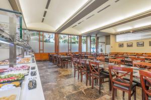 a dining room with tables and chairs and food at Hotel & Aparthotel Cosmos in Andorra la Vella